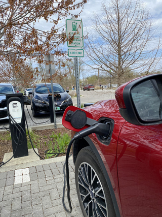 Red car plugged into a non-metered charging station at Switchyard Park in April 2024