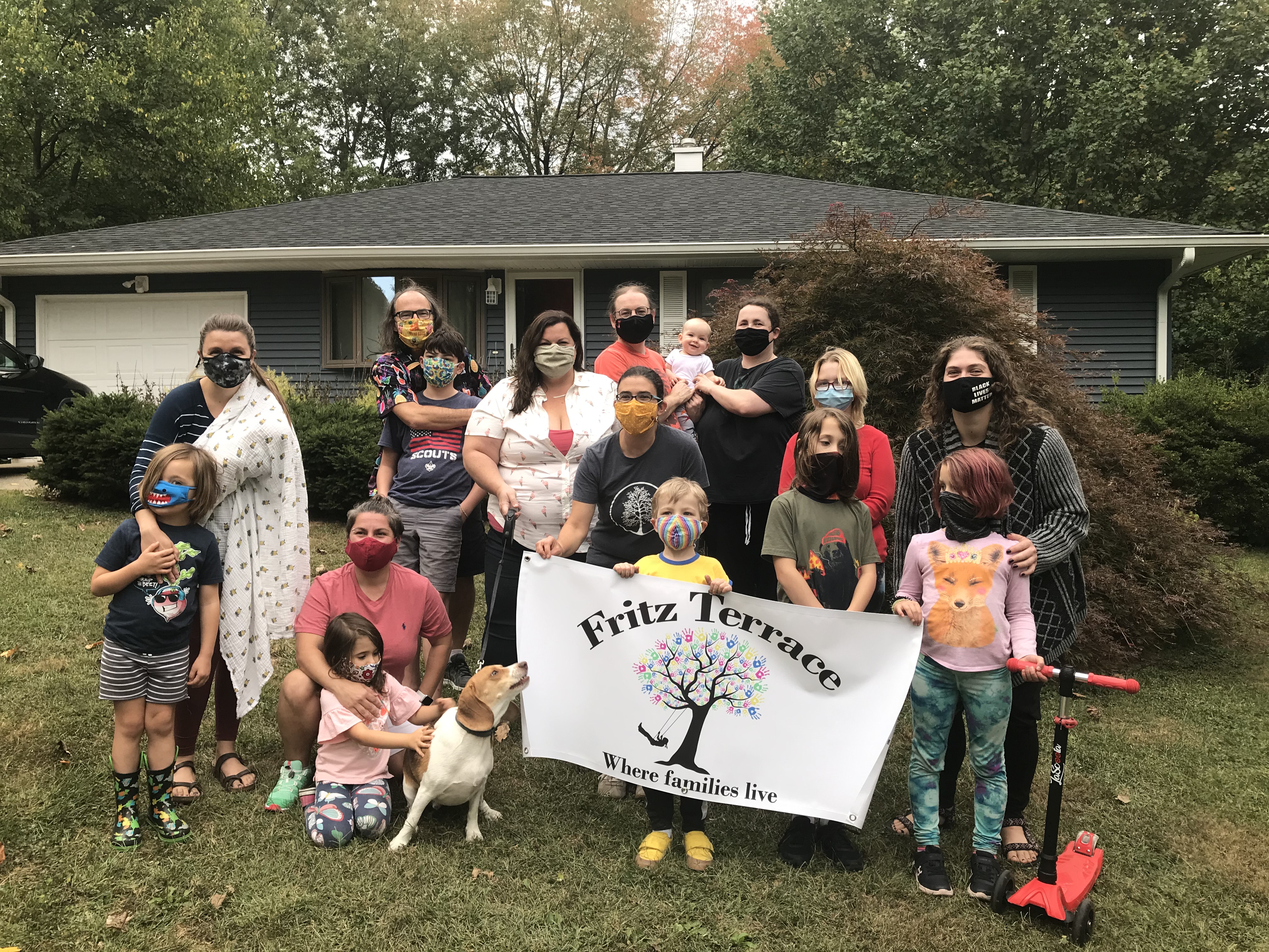 Fritz Terrace neighbors hold a banner depicting their neighborhood association logo