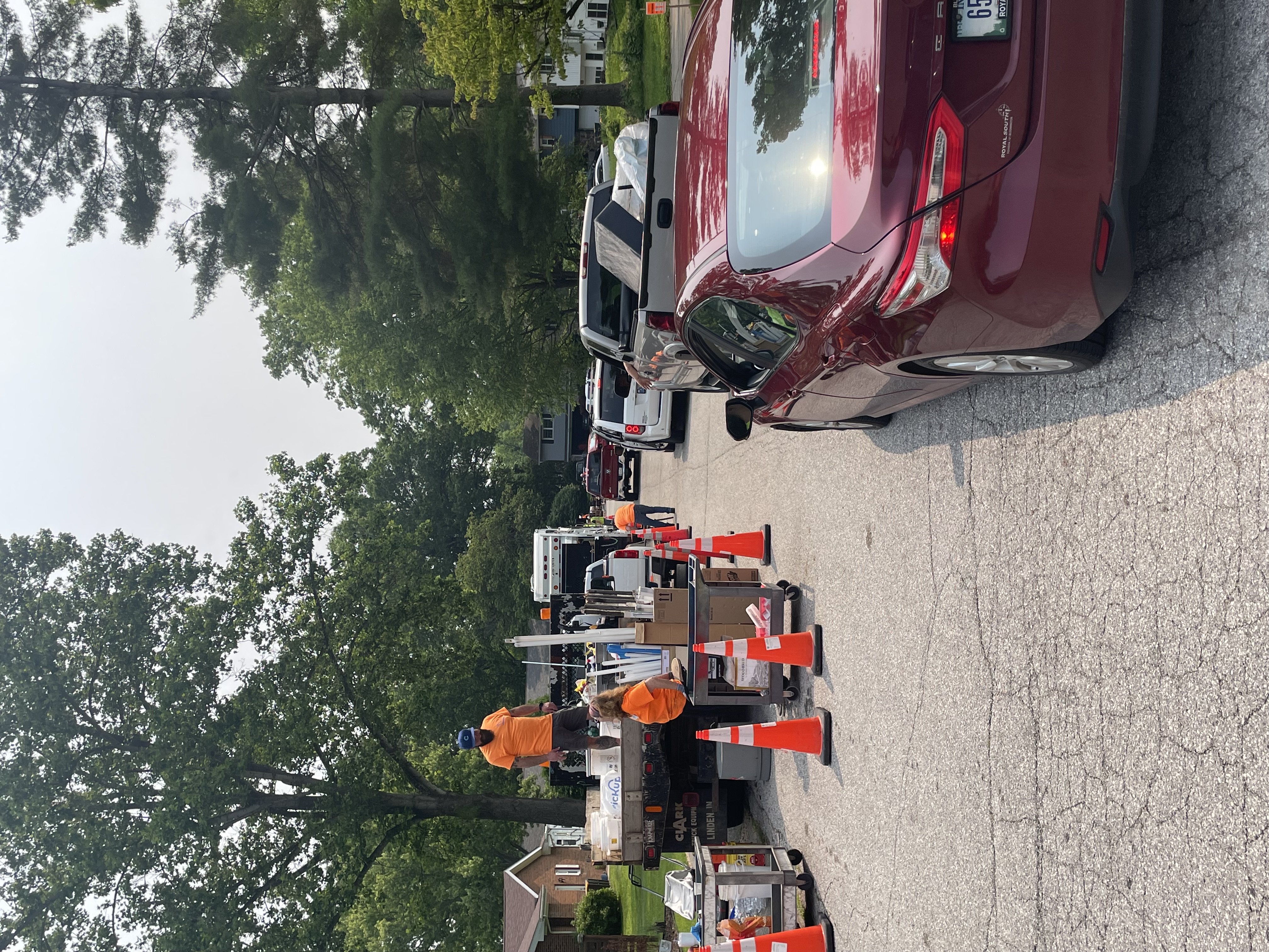 a line is cars waiting to drop off trash during a neighborhood cleanup day