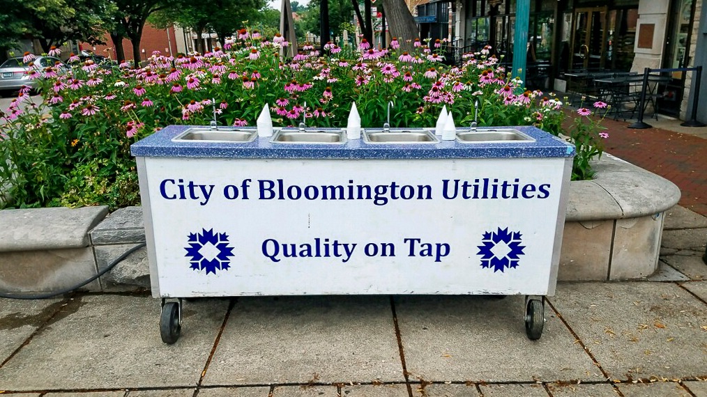 Water Cart with flowers behind it