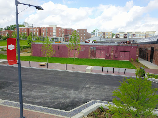 Picture shows the current state of the historic Showers Brothers Furniture Factory Kiln Building. It is a low, red building with no windows and three visible sets of heavy double doors.