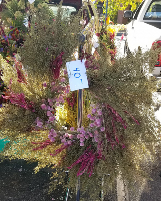 wreath of dried green, pink and red flowers