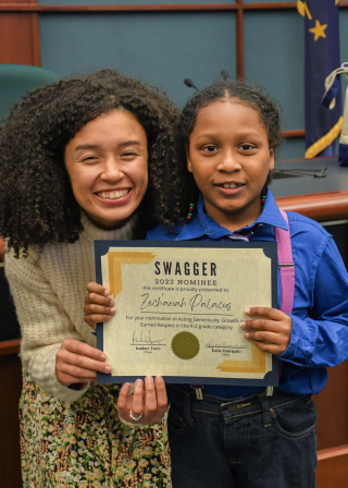 Katie Rodriguez with student winner in council chambers.