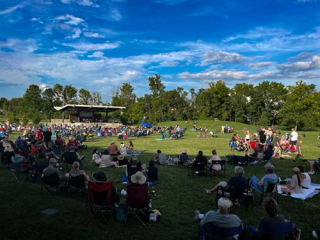 Switchyard Park main performance stage and lawn with crowd during a live show by The Dynamics