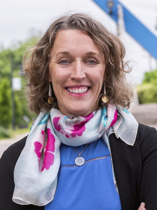headshot of Mayor Kerry Thomson with blue top, black cardigan and floral scarf