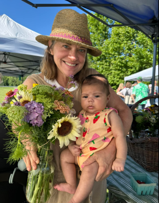 Julie of Littlest Bird Farms holding a bouquet and her grandchild