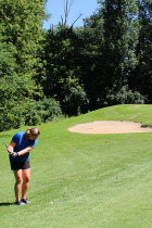 Woman golfer chips ball toward the green on the Ridge Course at Cascades Golf Course