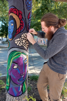 Fiber artist wrapping a tree in love