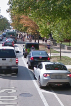 E 3rd St showing cars parked in the bike lane on the right side of road